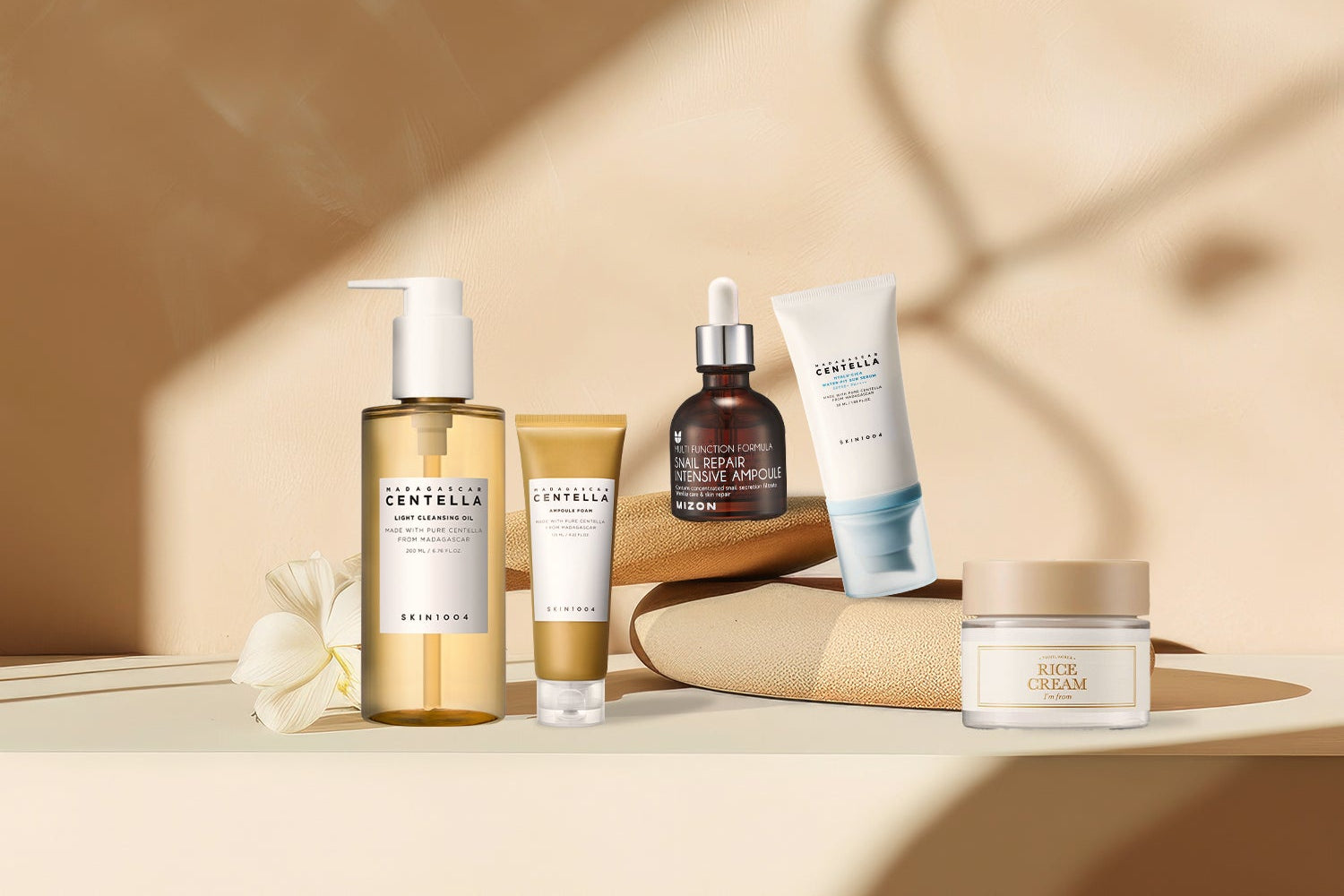 Collection of skincare products on a beige surface with a soft, warm background